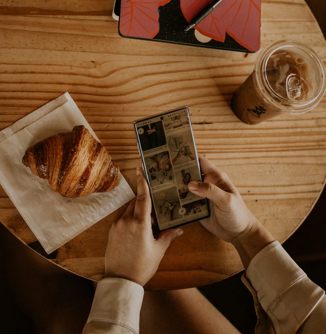 Photo of hands holding a phone in a cafe
