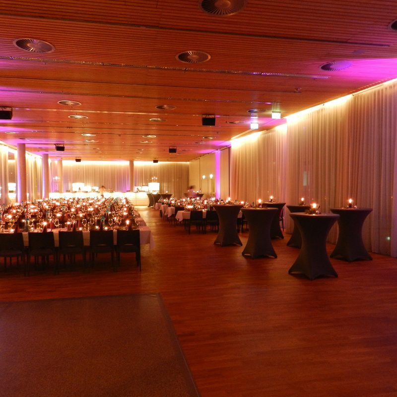 Großer Eventsaal mit Buffet, Stehtischen und stimmungsvoller Beleuchtung