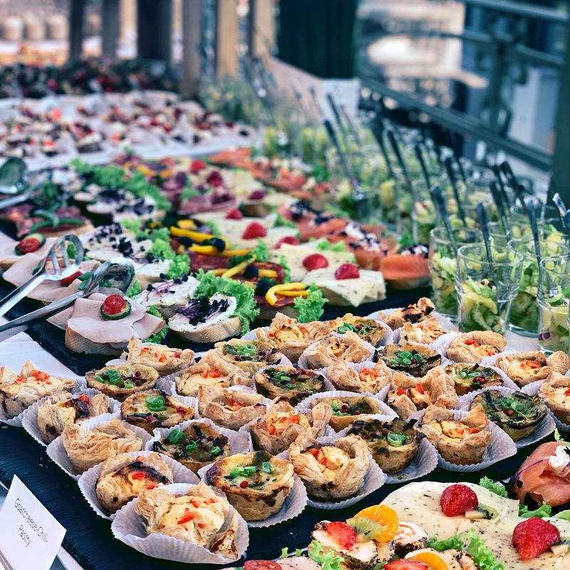 Fingerfood-Arrangement auf großer Tafel mit Pflanzen-Deko