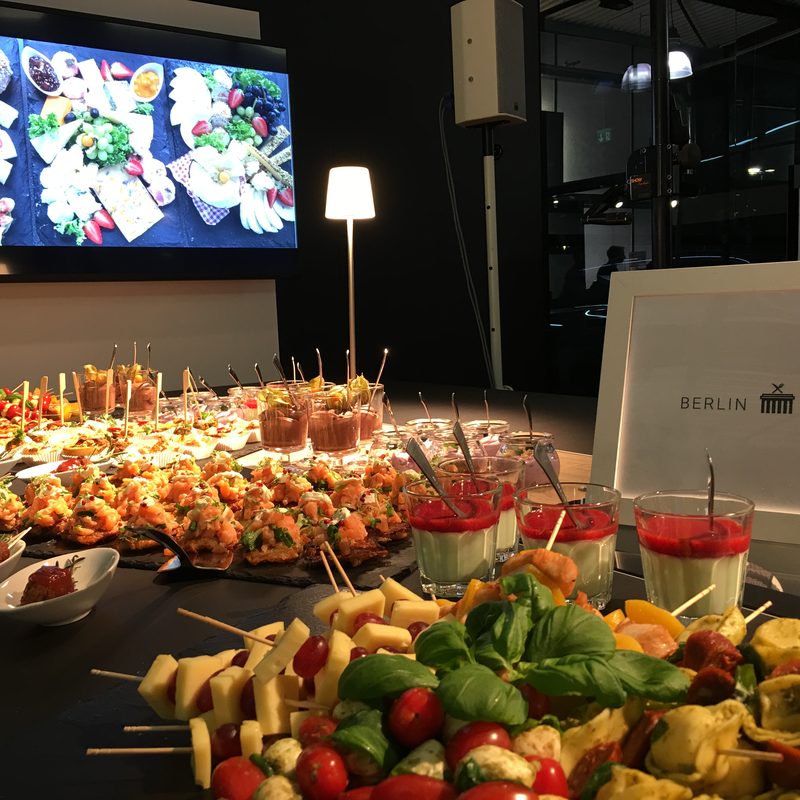 Catering-Station mit Spießen, Dips und leuchtendem Hintergrund