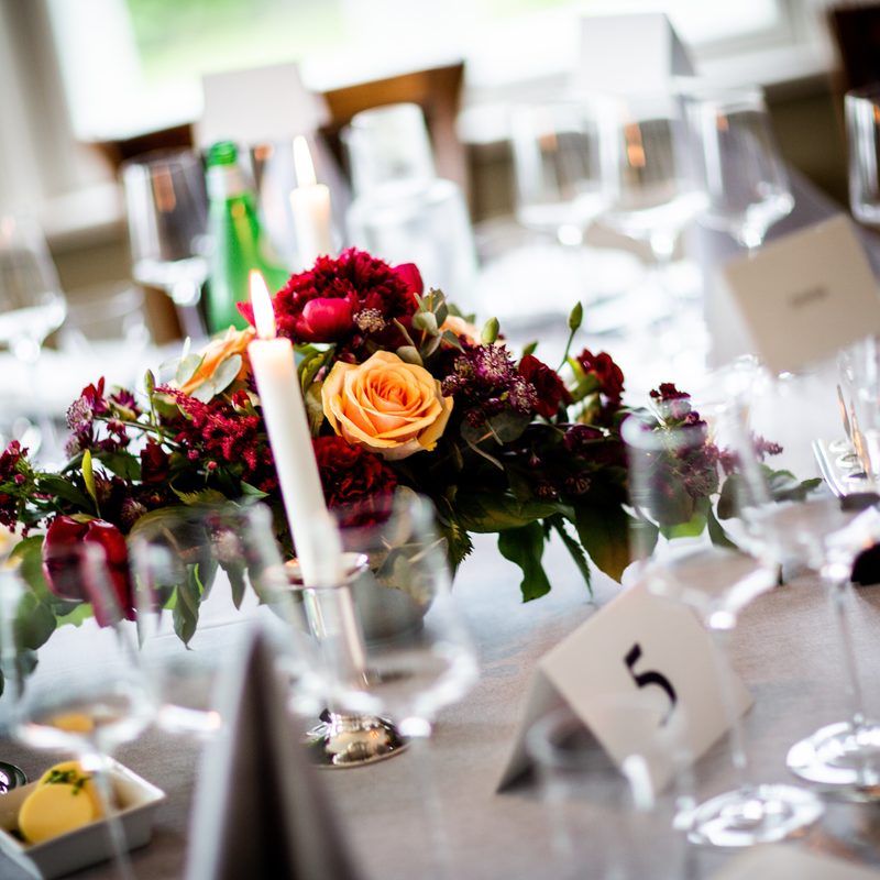 Tischdeko mit Blumengesteck und Tischkarte in Nahaufnahme